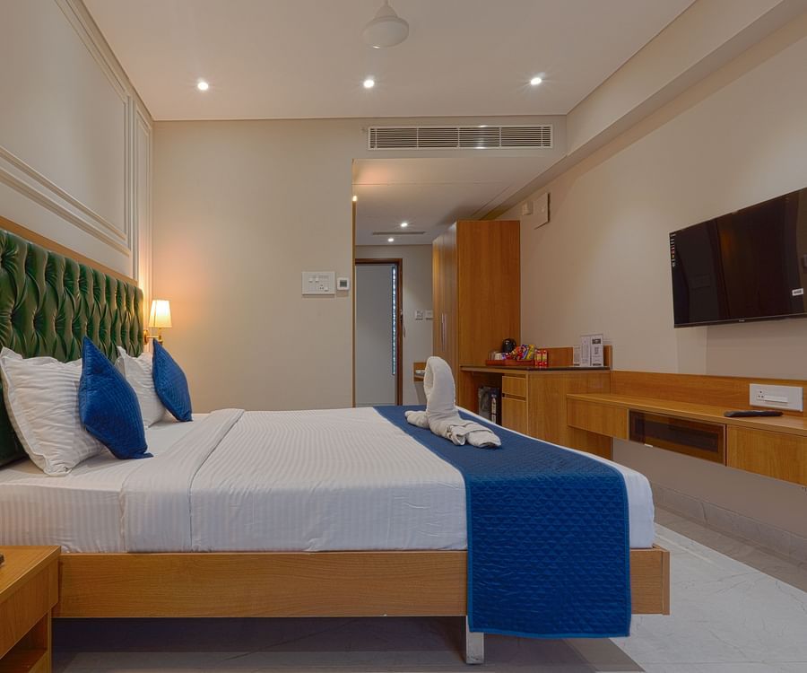 A double bed with side tables and lamps inside deluxe suites - Magnus Nexstar Suites, Pune