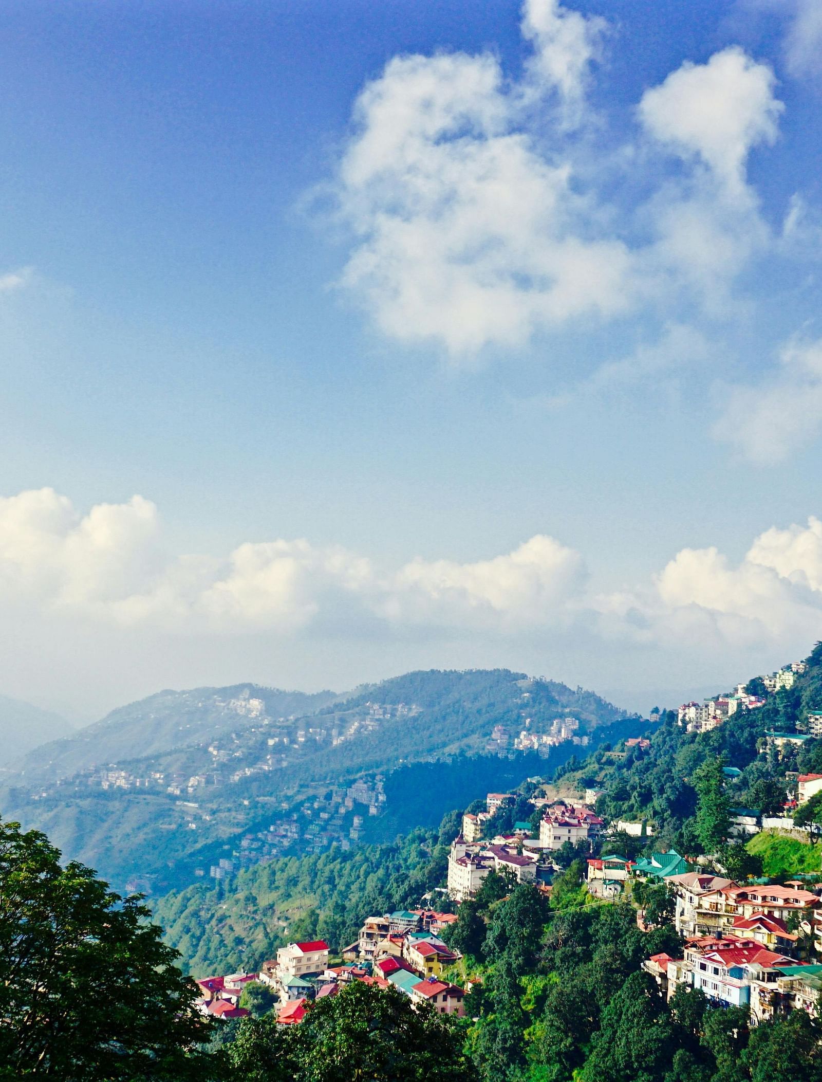 a beautiful landscape of shimla with vast blue skies and mountain ranges