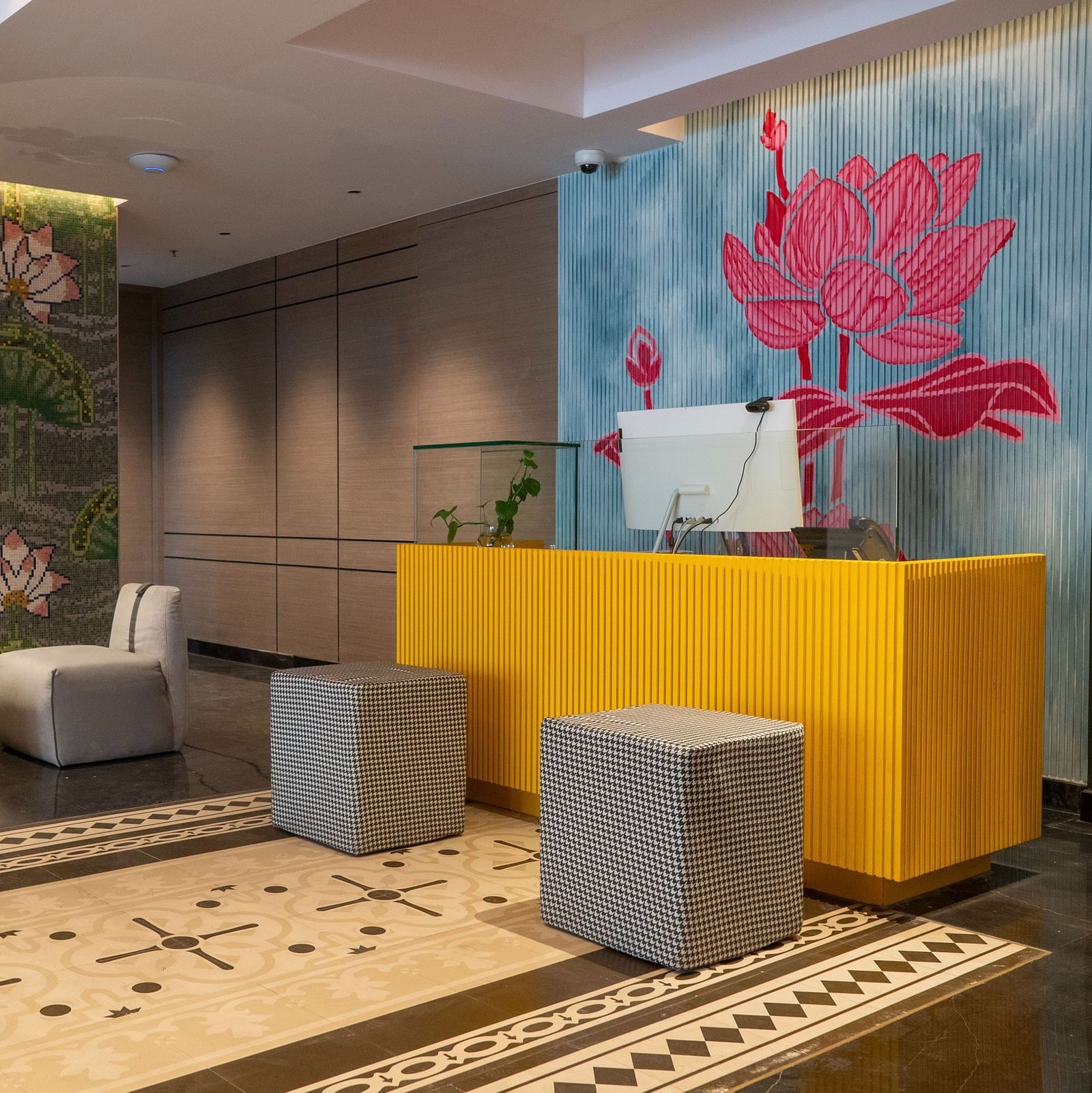 an image of reception area with flower wall paintings at Zibe Luxe Kakinada by GRT Hotels