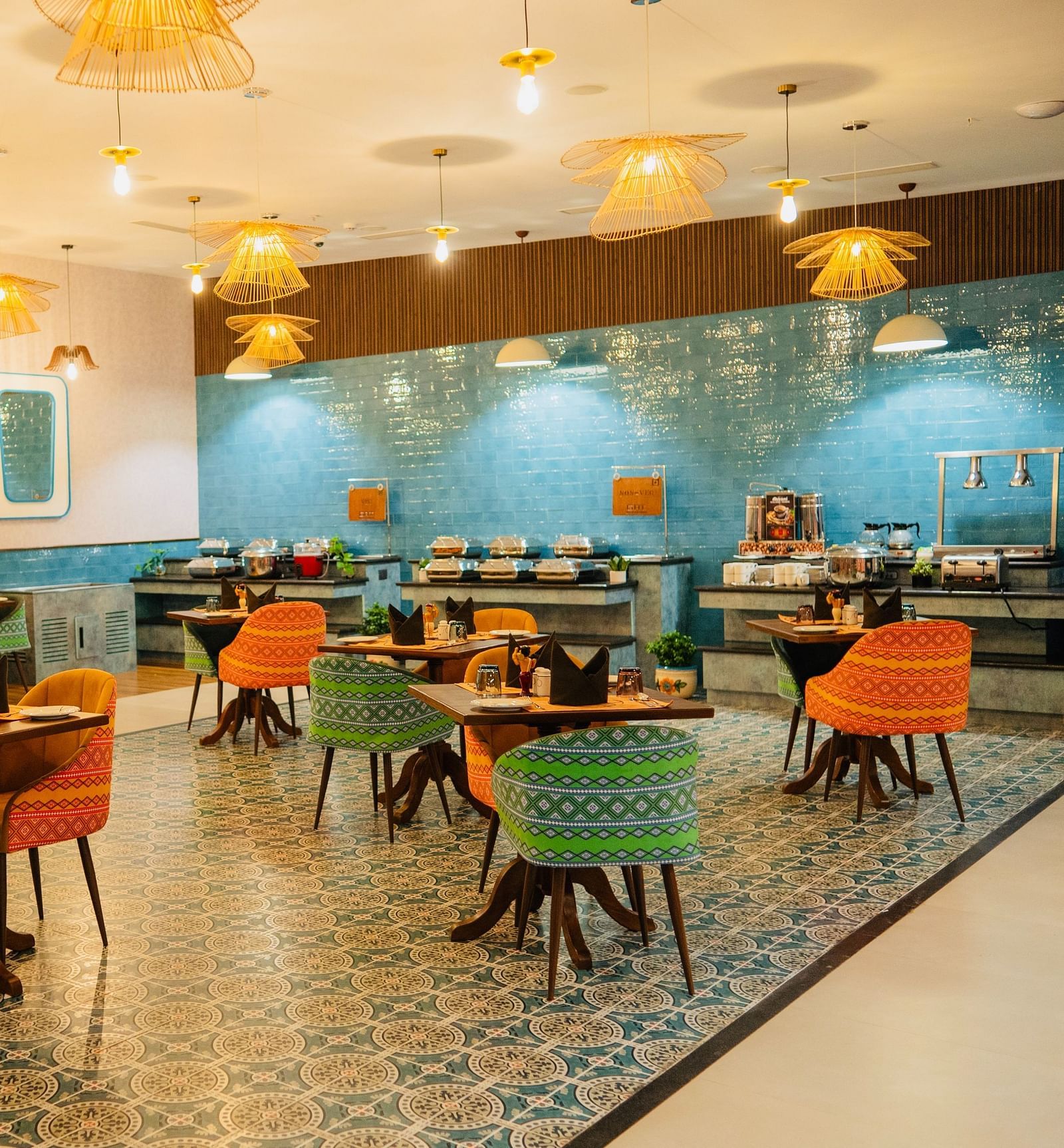 A dining area with chic hanging lights illuminating the table at Zibe Luxe Kakinada by GRT Hotels
