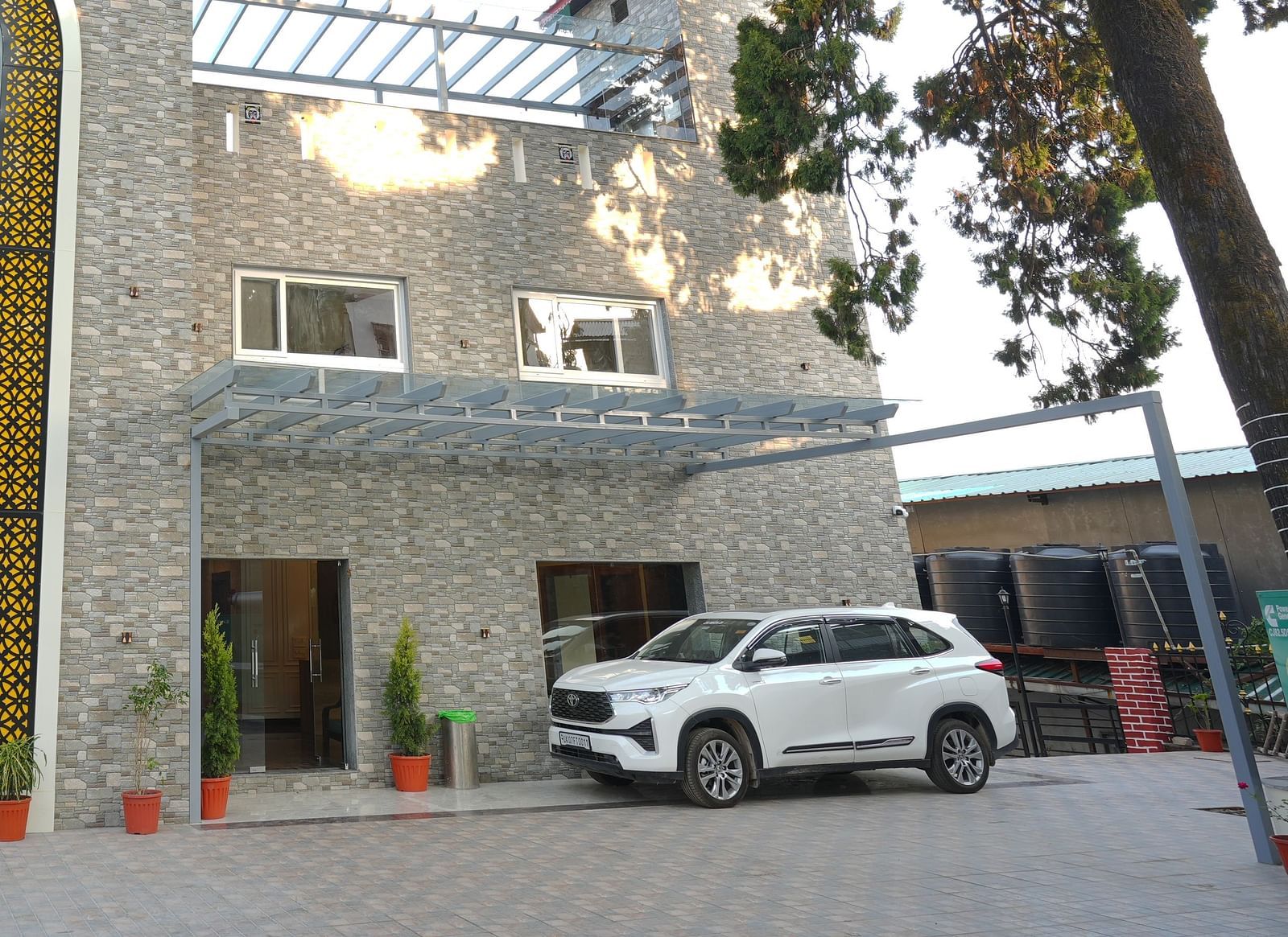 Facade view of DLS Oak Bush, Mussoorie with car parked outside.