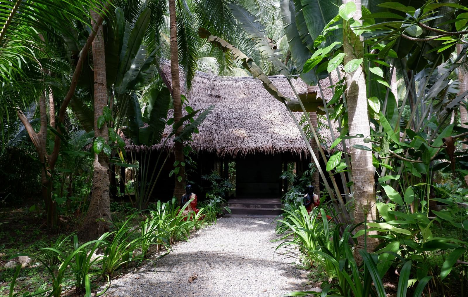 Shaded garden path leading to a bamboo villa at Flower Island Resort.