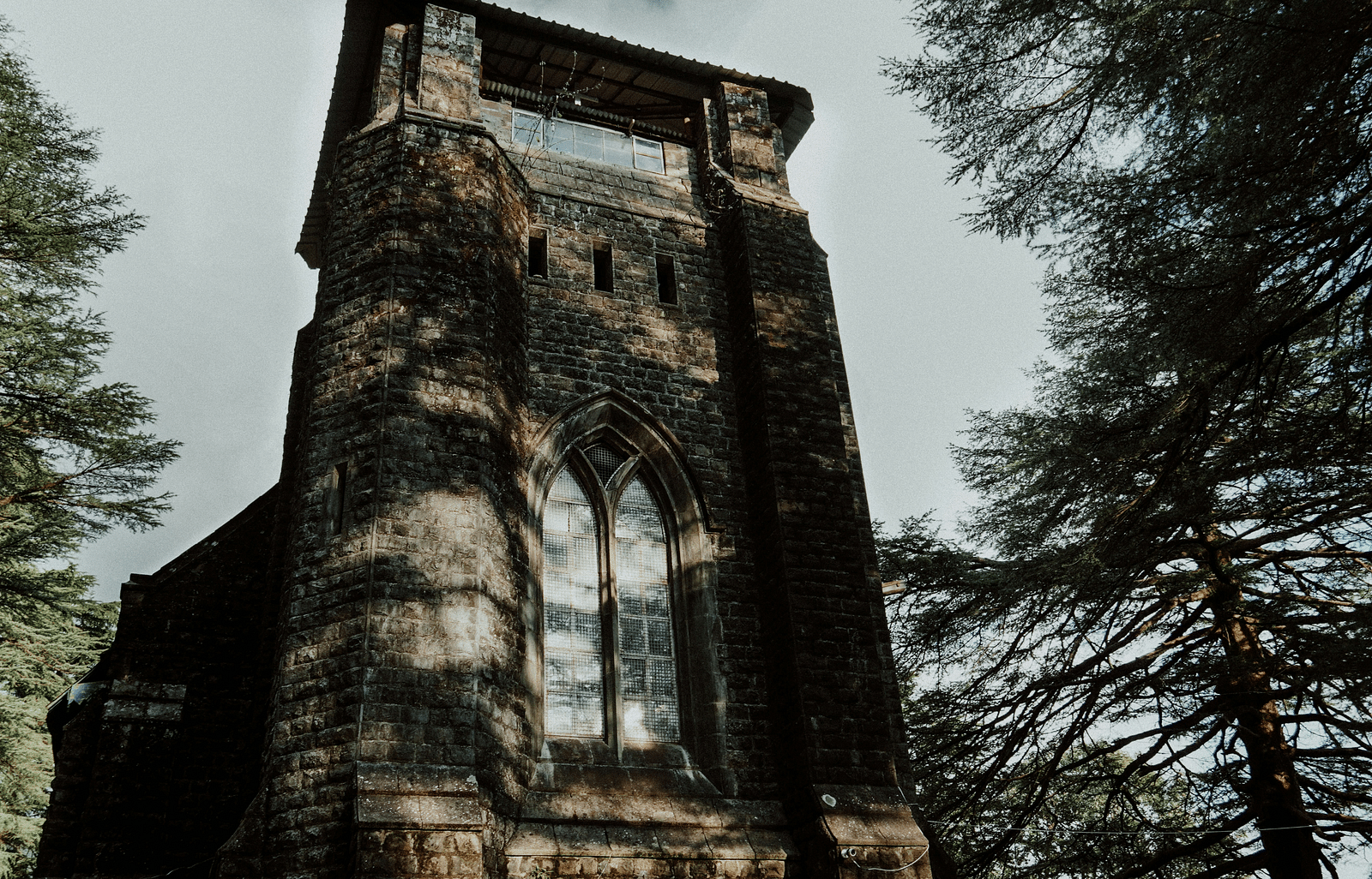 A facade image of a church with trees around it