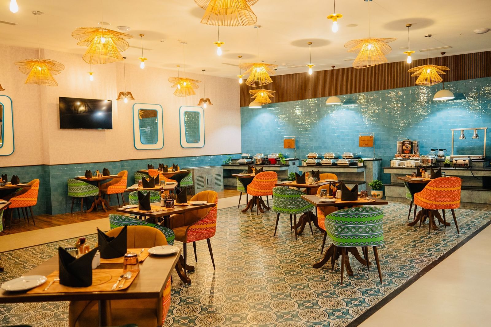 A dining area with chic hanging lights illuminating the table at Zibe Luxe Kakinada by GRT Hotels