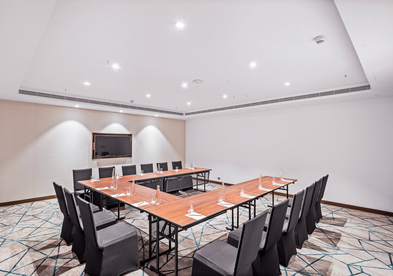 An image of a boardroom with an u-shape seating arrangement - Grand Vijaywada y GRT Hotels