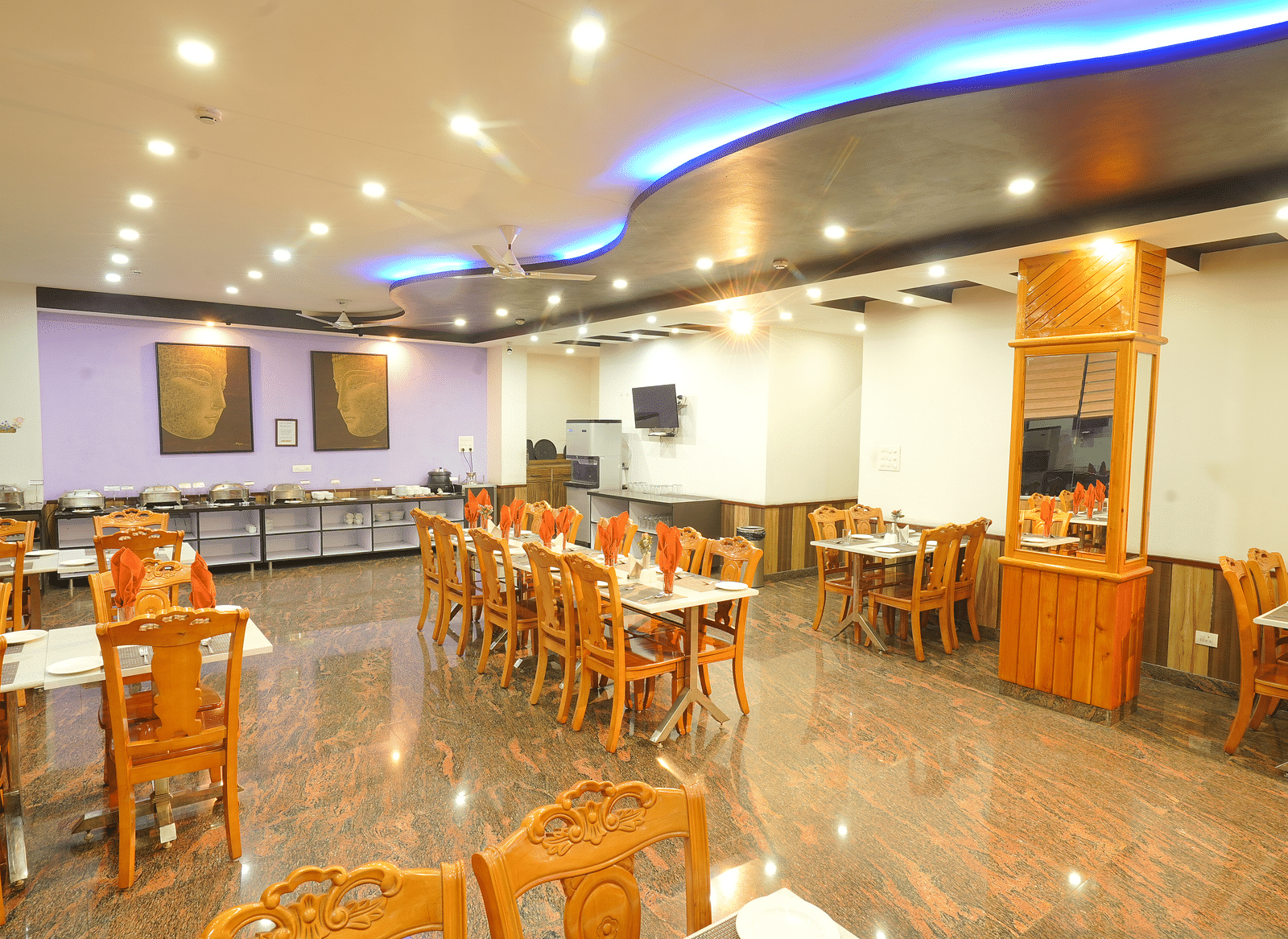 A long shot of the restaurant at the hotel featuring numerous tables and chairs | DLS Hotel Shiva Sanctuary & Spa, Dharamshala