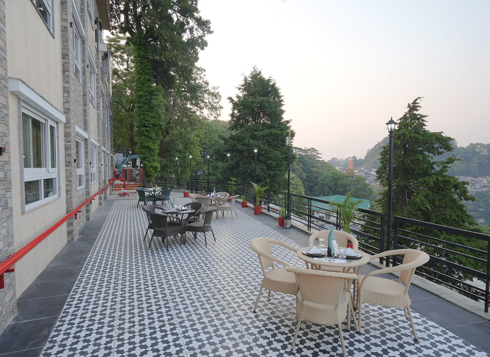An outside seating area with comfortable chairs around tables at DLS Oak Bush, Mussoorie.