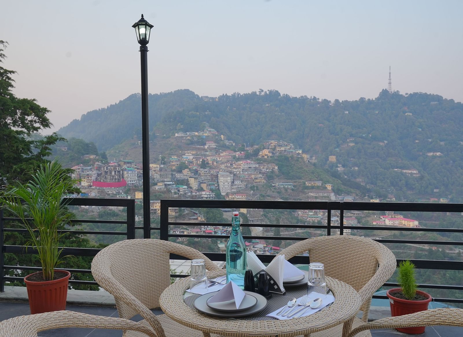 An outside seating area with comfortable chairs around tables at DLS Oak Bush, Mussoorie.