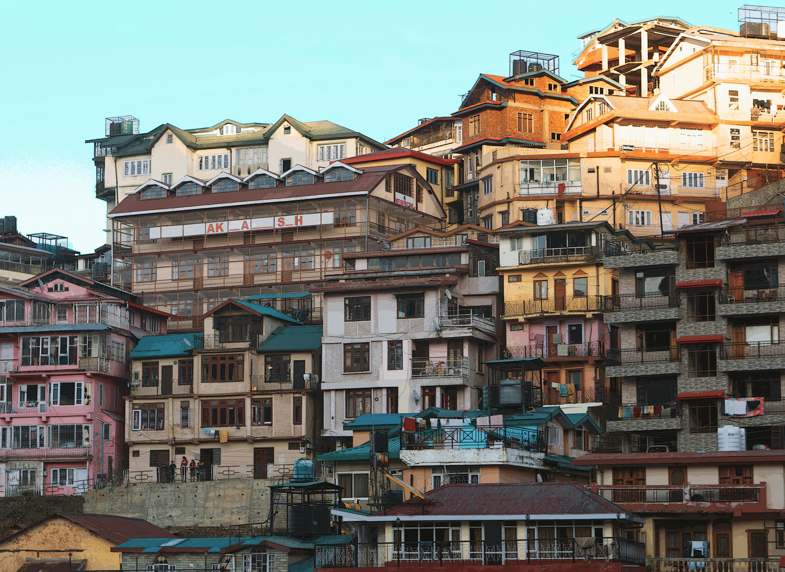 A cluster of multi-storey houses built closely on a hillside.