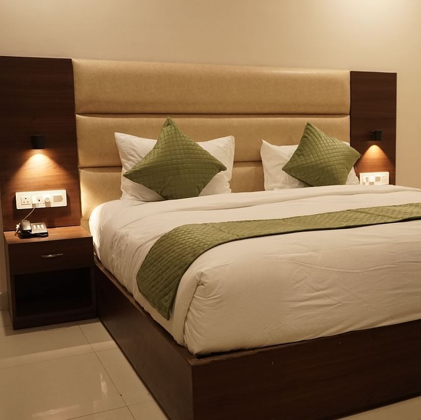 Deluxe room at Five Elements Hotels, Haridwar, featuring a king-sized bed with bedside lamps