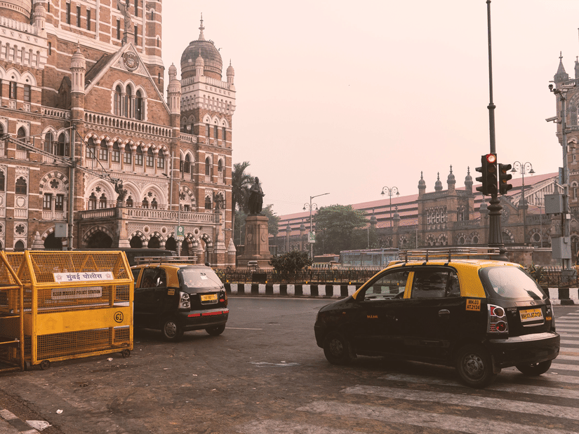 Historic heritage buildings overlooking a busy city intersection with taxis and traffic moving through the streets