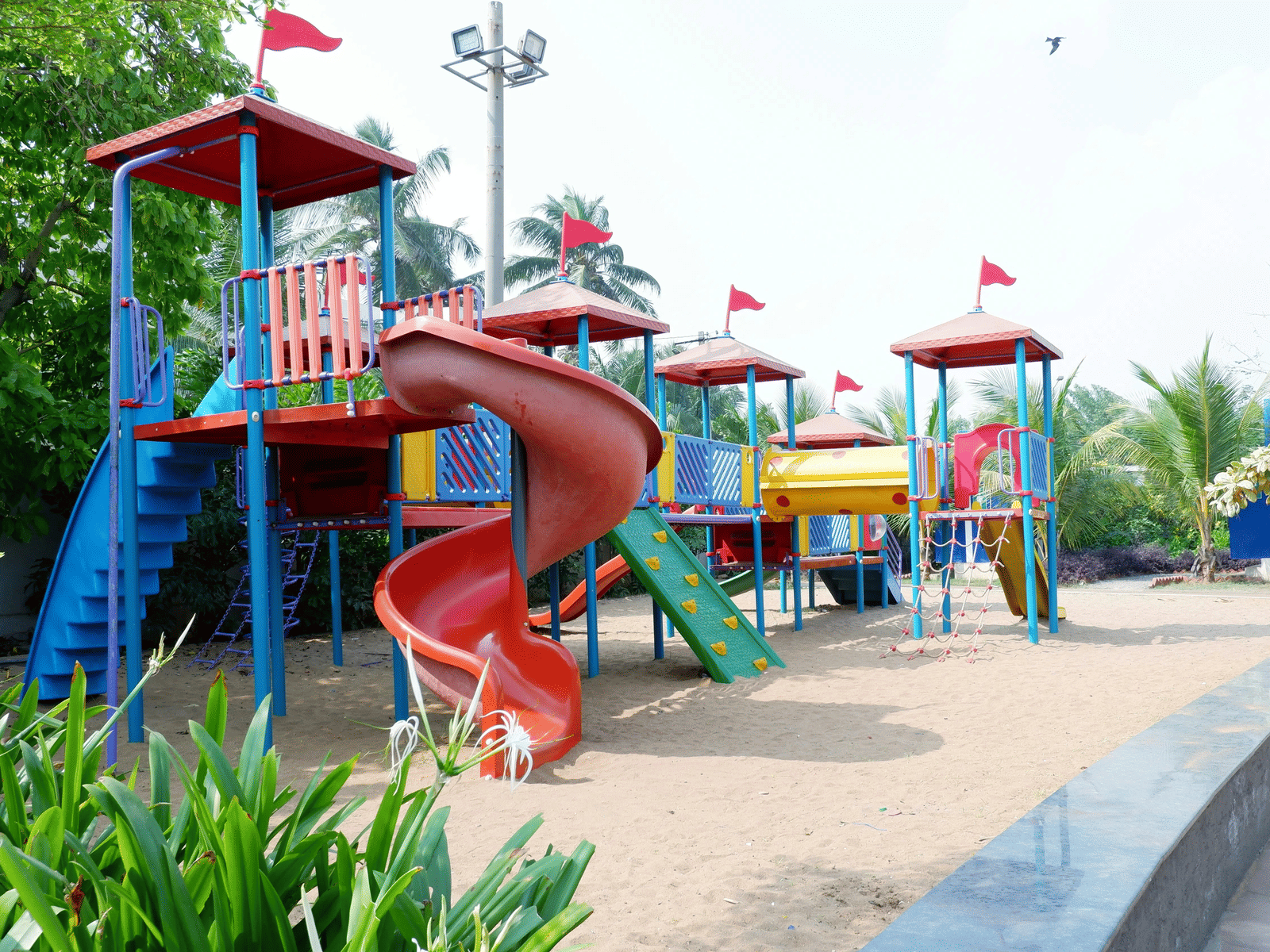 Children’s playground with colourful slides and climbing frames, surrounded by landscaped gardens, offering a safe and engaging outdoor space for families