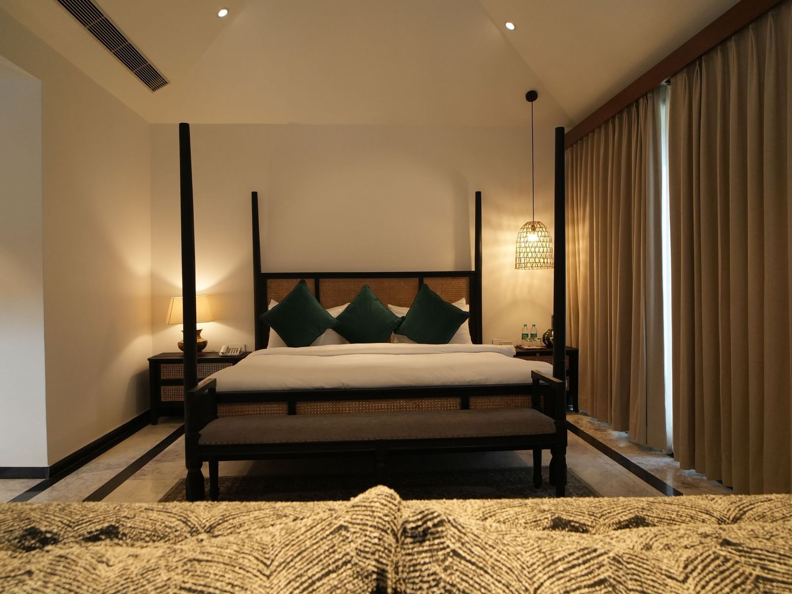 Front view of a room with a bed and window on the side at Surpura Bagh.