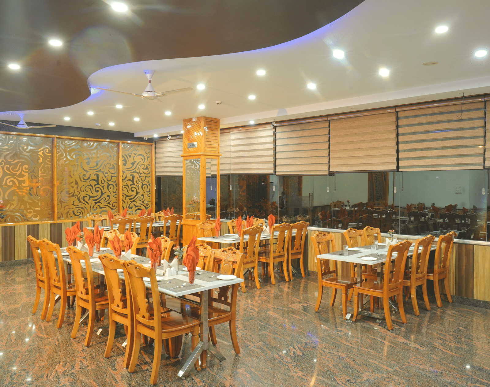 A large, well-lit restaurant with numerous tables and chairs and wooden accents | DLS Hotel Shiva Sanctuary & Spa, Dharamshala