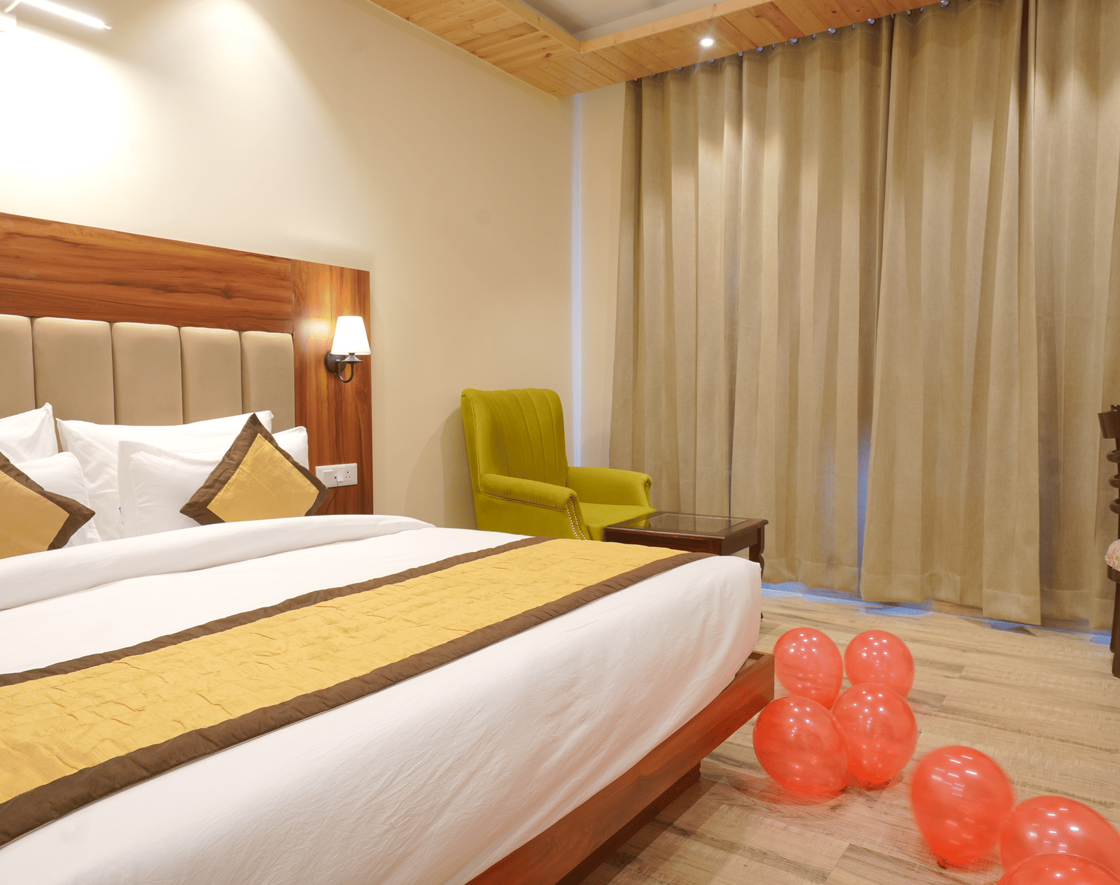 A large bed near a comfortable chair in Deluxe Room at DLS Oak Bush, Musssoorie.