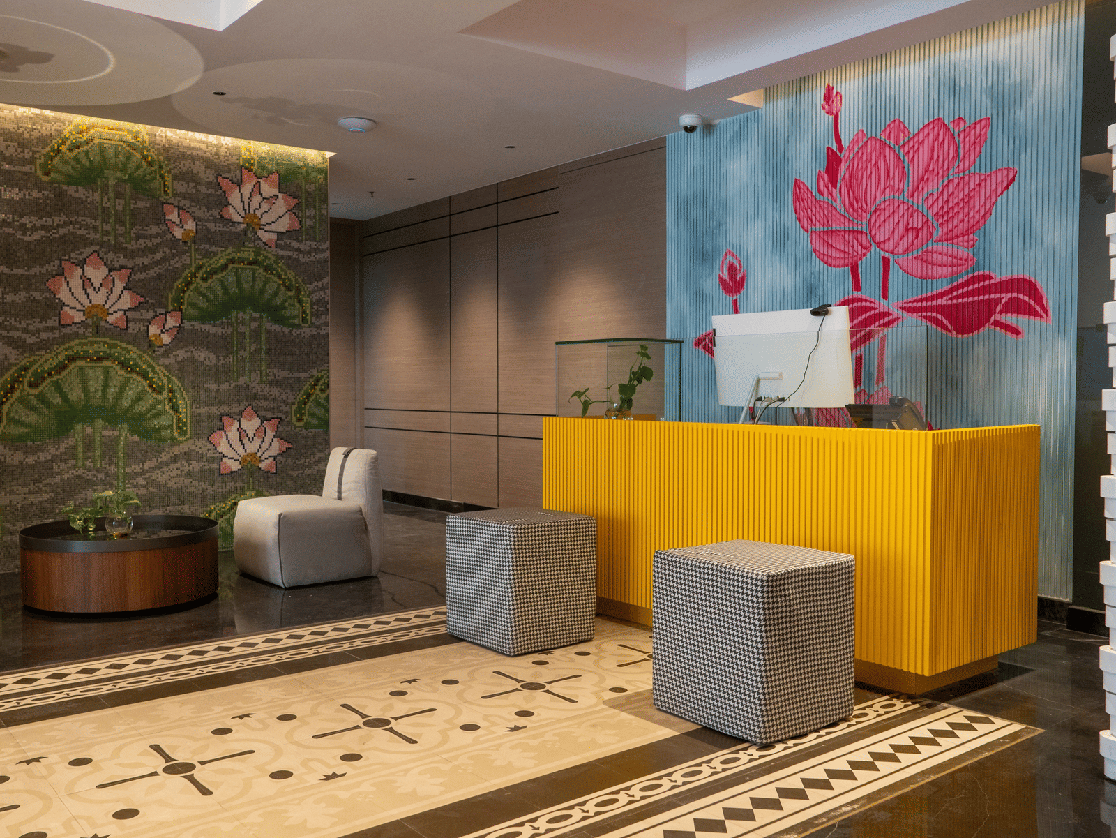 an image of reception area with flower wall paintings at Zibe Luxe Kakinada by GRT Hotels