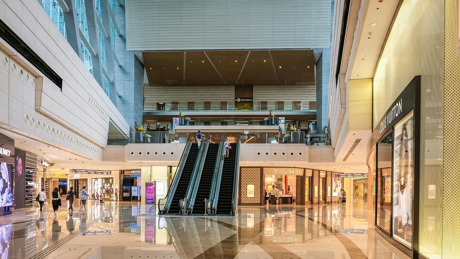 a shopping mall with an escalator going to the next floor.