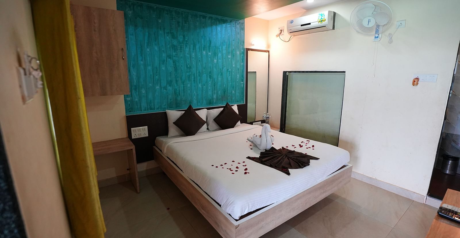 An image of a room with a bed, bed side tables, and air conditioner - Nisarga Lake Resort