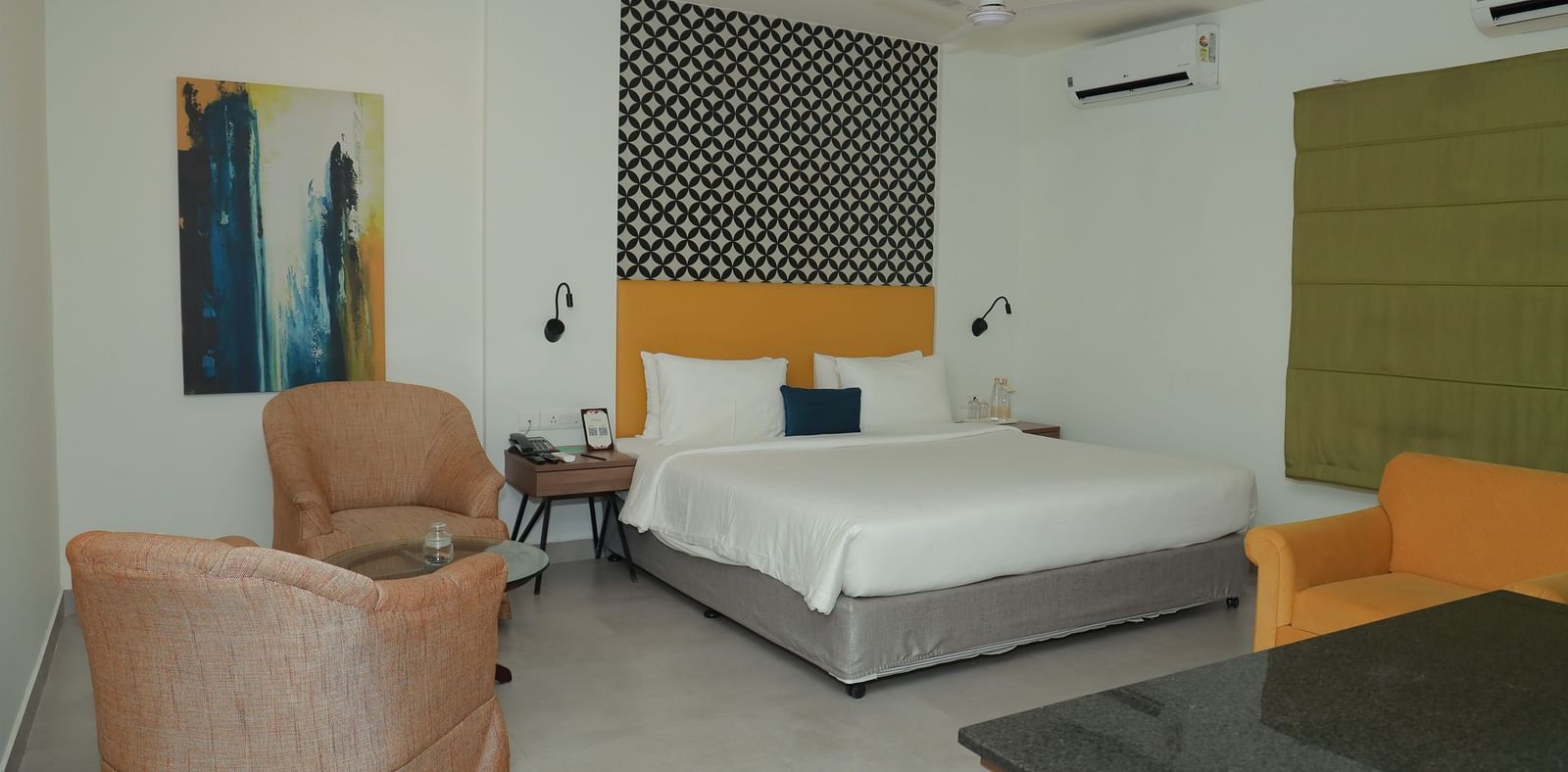 A Suite in Regency Tuticorin by GRT Hotels featuring a large bed and couches on the side and in front - Best Thoothukudi Rooms for Extended Stays