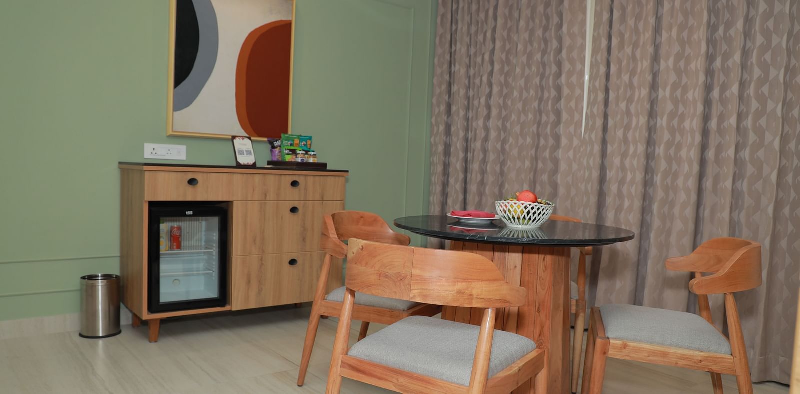 An image of our relaxing area in the suite, featuring a coffee table with chairs around it and a table lamp in front - Regency Tuticorin by GRT Hotels