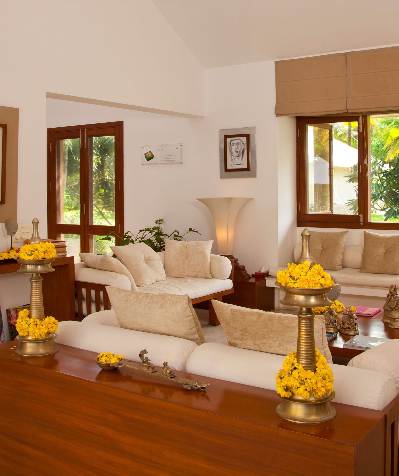 Living room with a couch, wooden table, and decorative items, bright interior - Shreyas Retreat