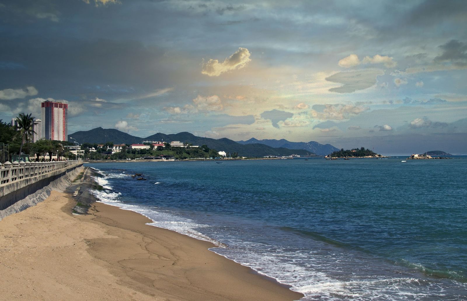 An overview of a beach in Nha Trang with a lighthouse in view and dark clouds above