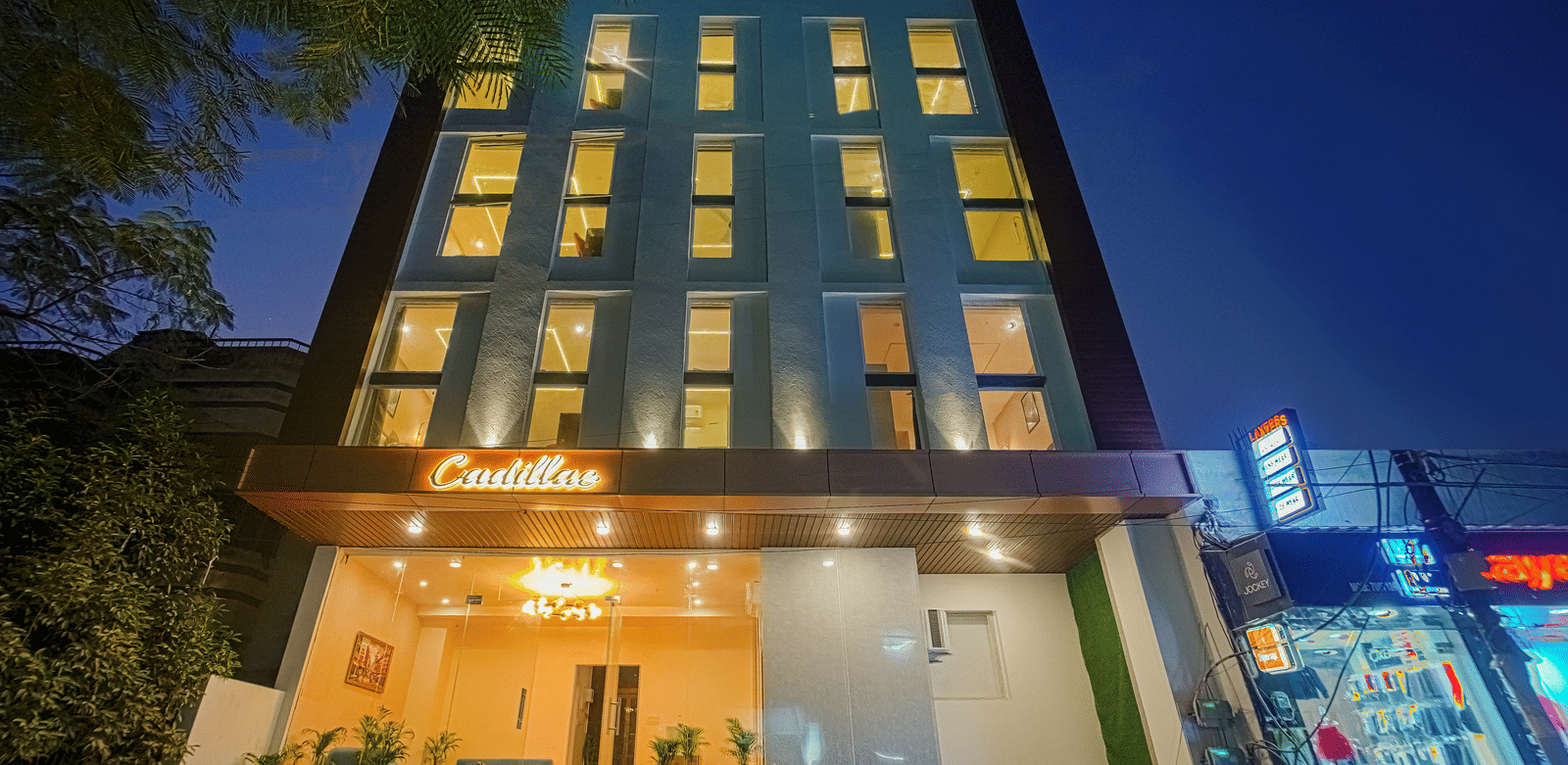 The exterior of Perfectstayz Premium Varanasi building illuminated at night, with a ground-floor entrance.