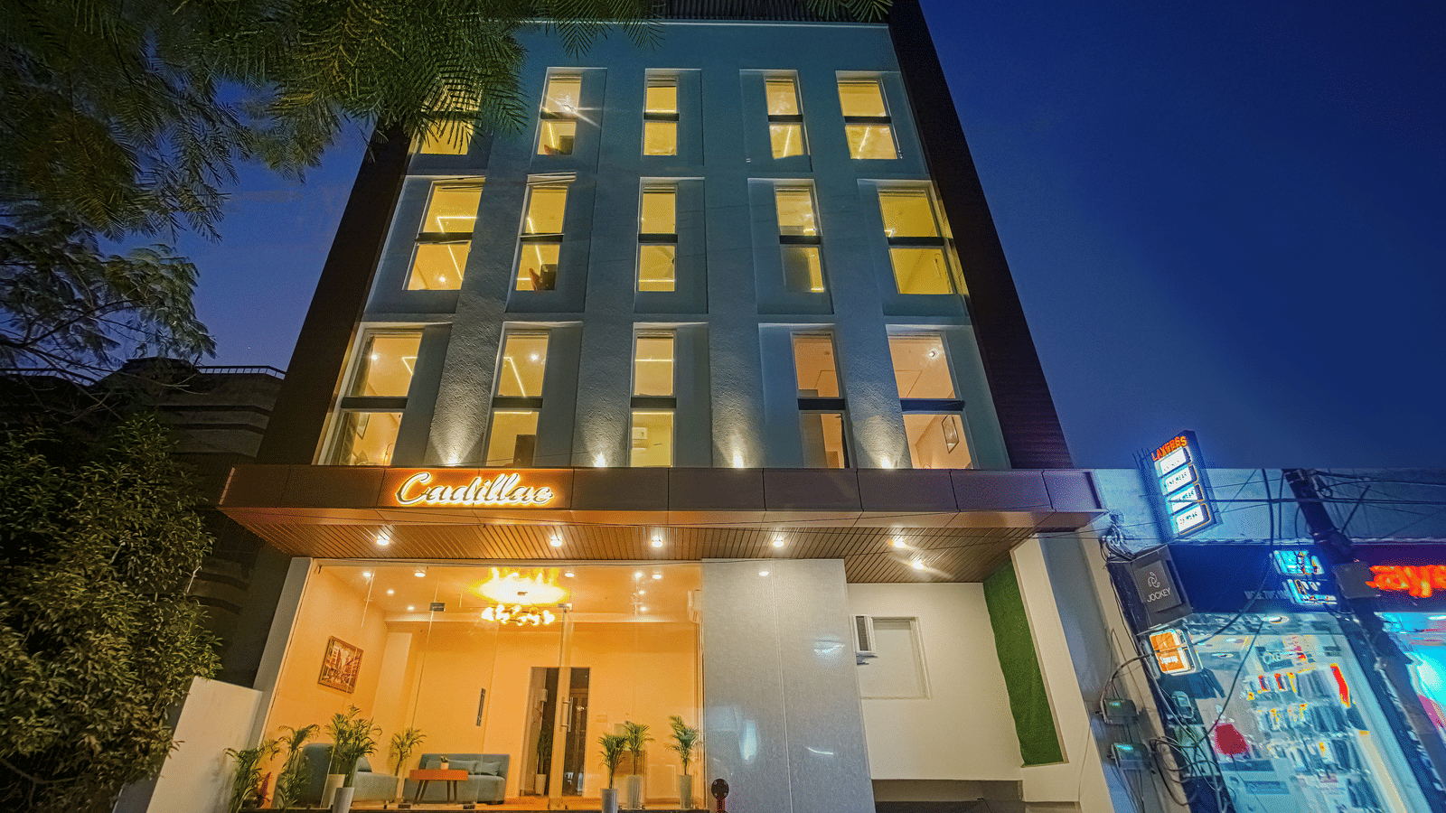 The exterior of Perfectstayz Premium Varanasi building illuminated at night, with a ground-floor entrance.