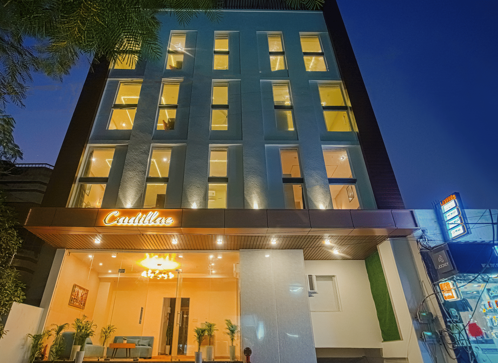 The exterior of Perfectstayz Premium Varanasi building illuminated at night, with a ground-floor entrance.