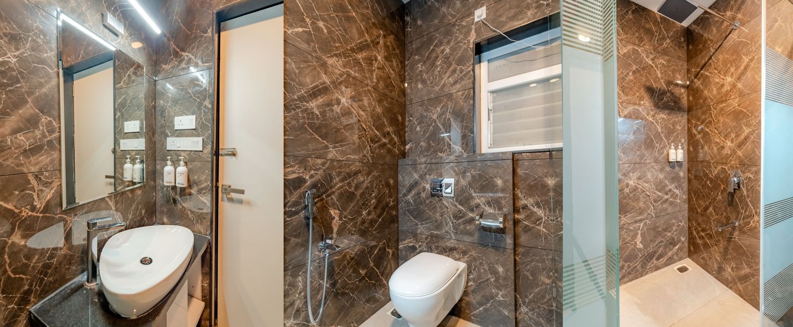 Modern bathroom with a sleek vanity, toilet, and glass shower enclosure | Superior Room | Pravasa Hotel, Vijayapura