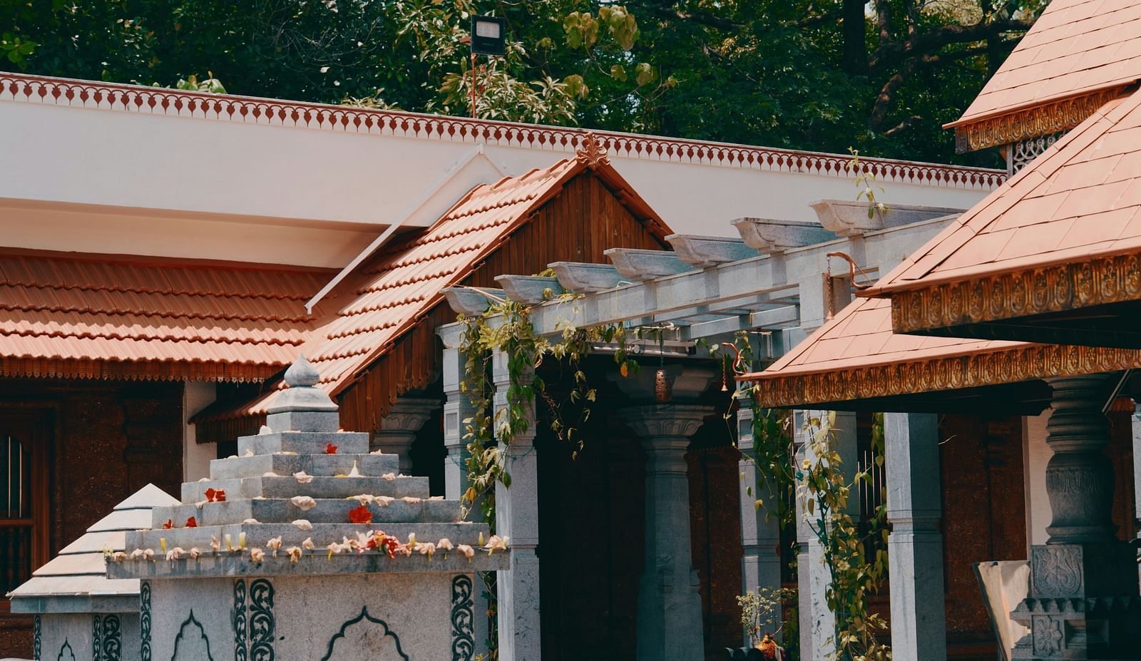 A vishnu temple in front of a building with trees in the background