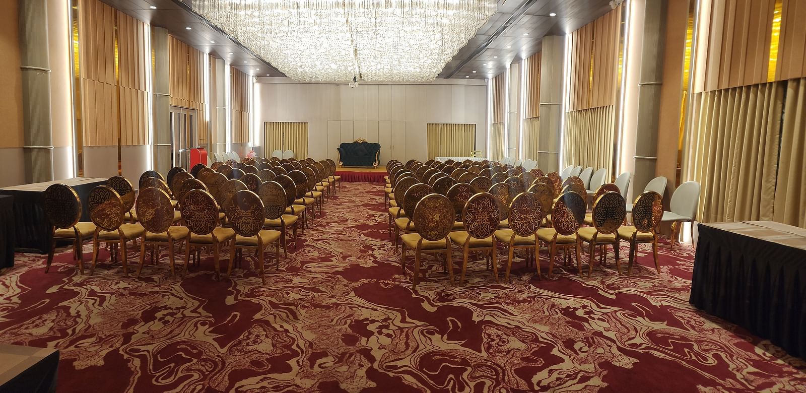 Another view of the same conference room with plush seating and elaborate lighting, focused on the central aisle.