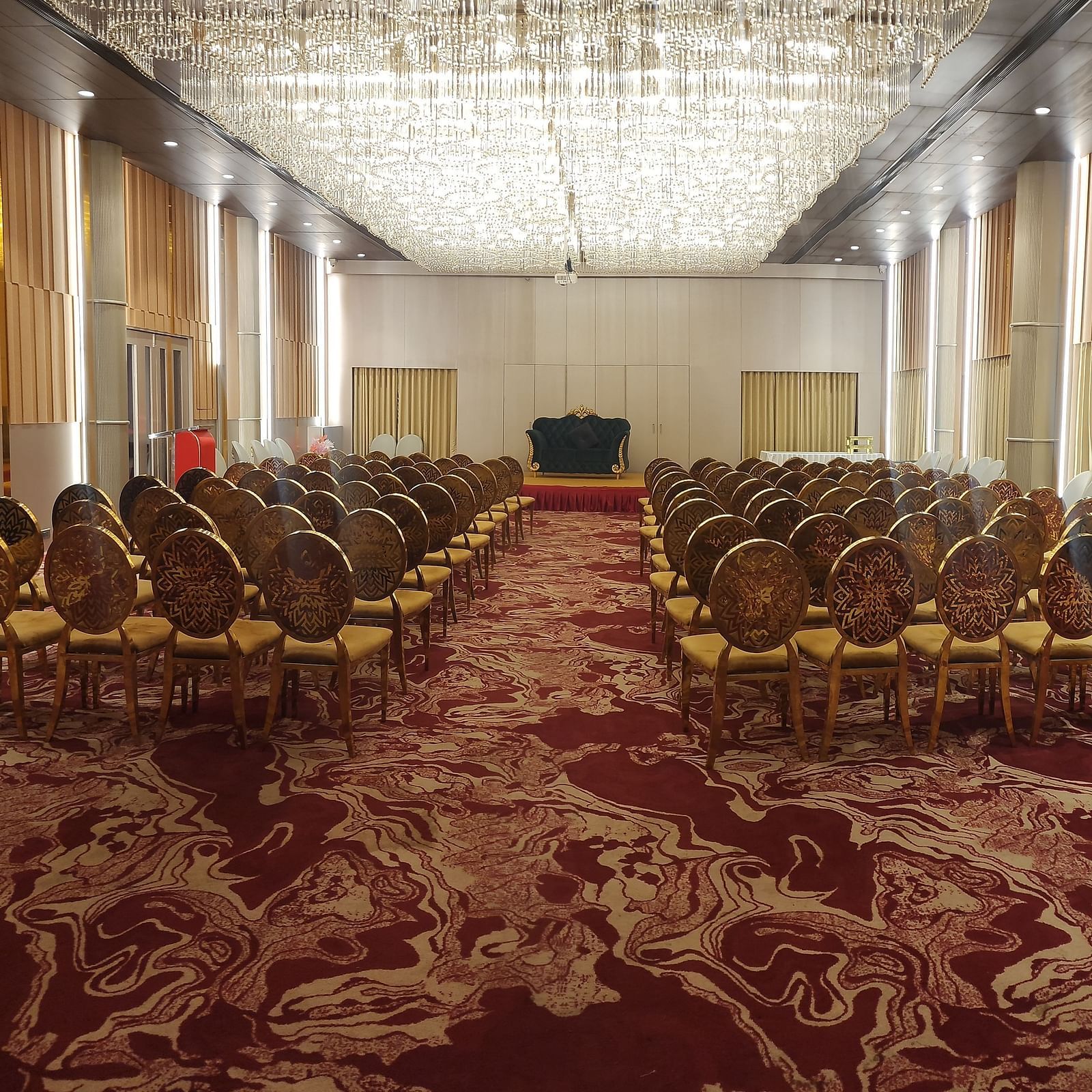 a banquet hall at Lords Inn Rajkot with theatre style seating arrangement and a stage at the front