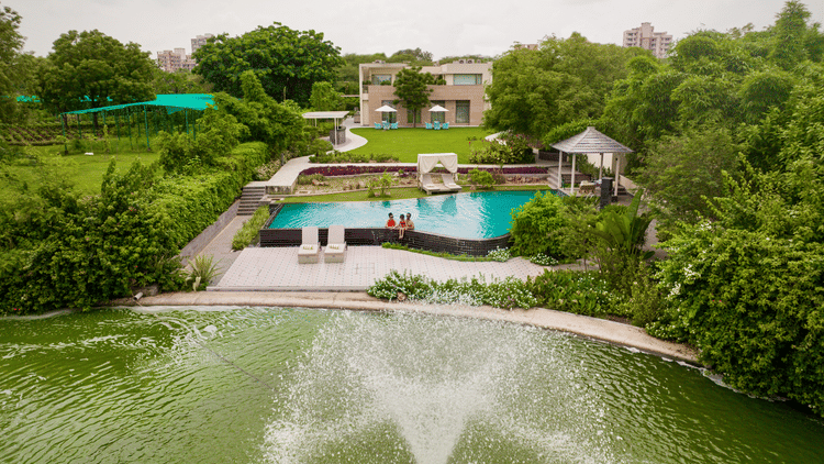An aerial view of the Presidential Villa with a fountain in front of it - Karma Lakelands.