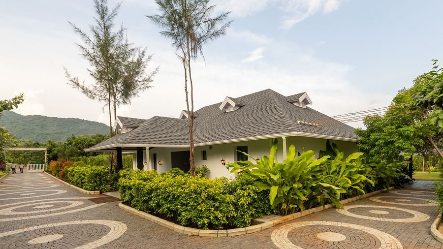facade image of the luxury group stay villa surrounded by lush greenery with a beautiful clear evening sky in the background - Darza Resorts