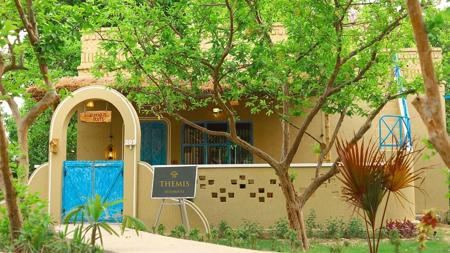 exterior view of the Classic Villas at semi arched gate with blue door at Themis Mudhouse - A Nature's Retreat Resort & Wellness