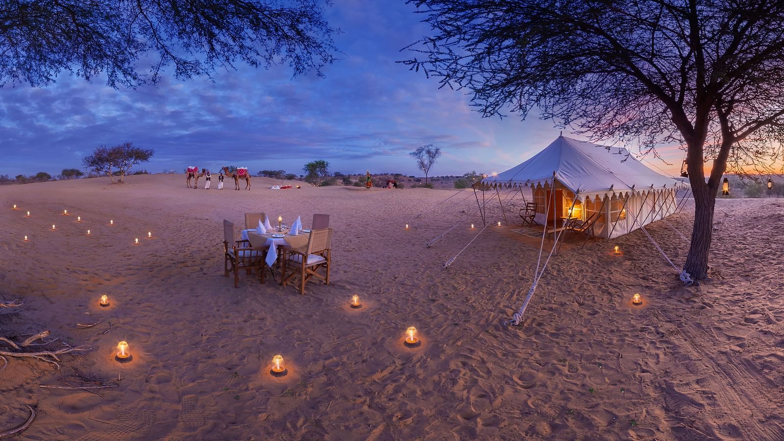 A breathtaking sunset view over the desert, with the campsite situated along the trail, highlighting the vastness of the landscape - MANVAR Resort & Desert Camp