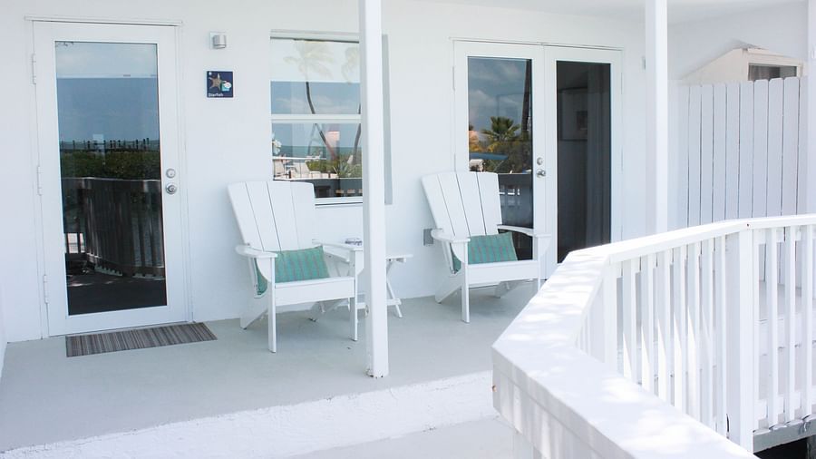 outside sitting area at casa morada with two white chairs and blue cushions. 