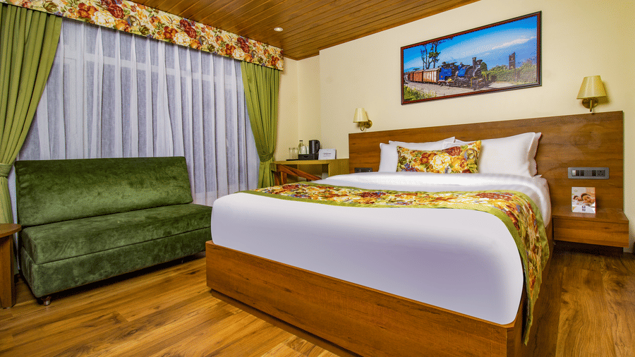 Premium Room featuring warm wooden interiors, king size bed, green sofa seating, and spacious layout | Mount Lungta Boutique Hotel & Spa