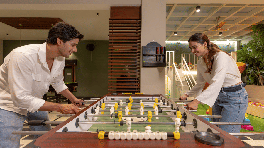 People playing a game of foosball in an indoor common area at The Golden Tusk, Jim Corbett