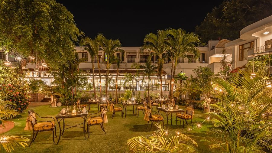 an outdoor dinner setup with twinkling lights and candles for a wedding celebration