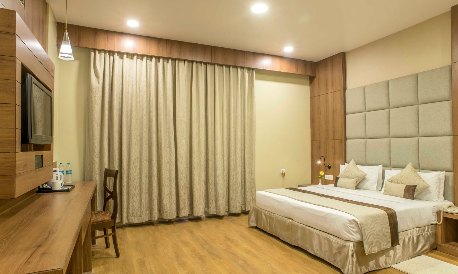 Comfortable hotel room with a double bed, a work desk, and beige curtains | The Citi Residenci Hotel Durgapur