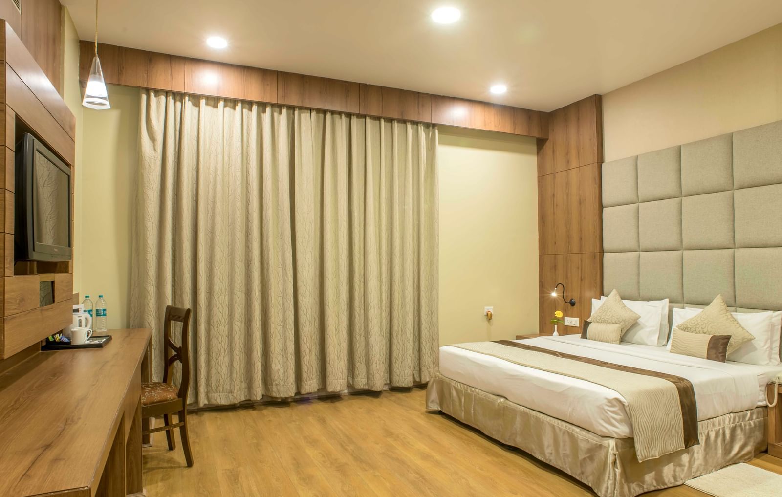 Comfortable hotel room with a double bed, a work desk, and beige curtains | The Citi Residenci Hotel Durgapur