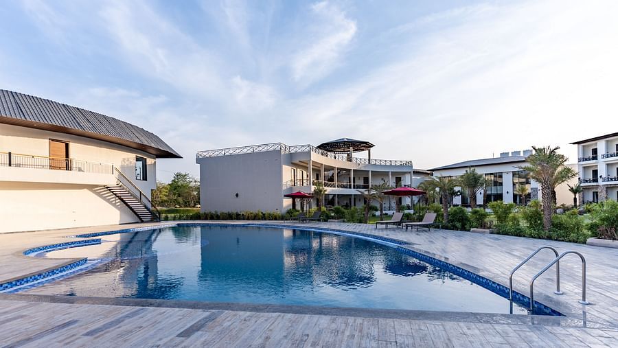 A well maintained swimming pool in front of our hotel rooms seen on a sunny day - Shervani Pebbles & Pines, Corbett