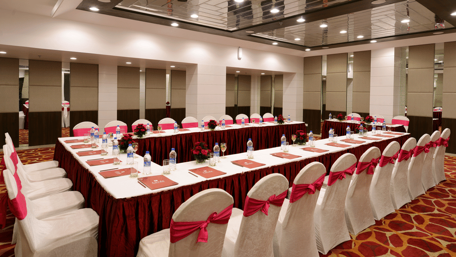 Board room seating arrangement with well-lit ambience and water bottles on the table