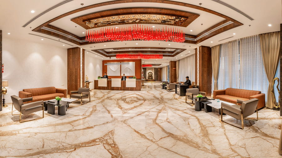  A spacious hotel lobby with polished marble flooring, tan leather seating, and vibrant red glass chandeliers hanging from a recessed ceiling - Skkylight Lords Inn, Nanded