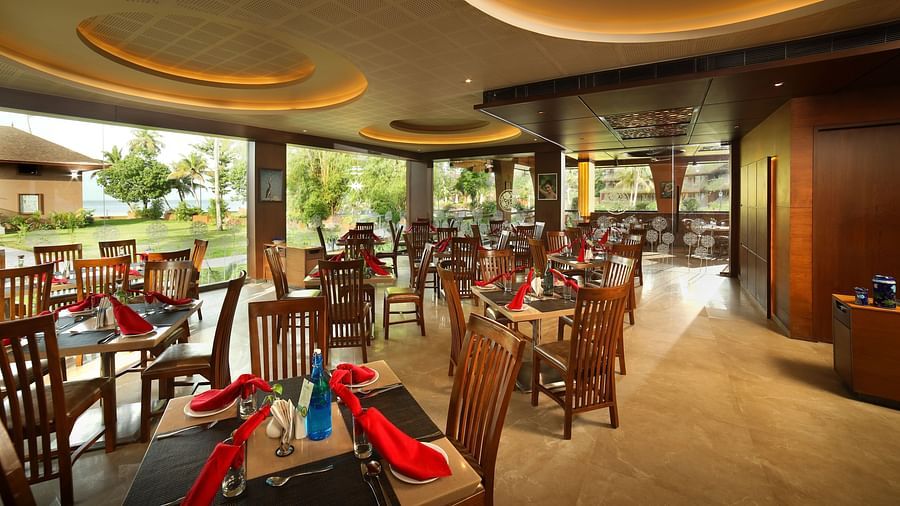 Aambal Restaurant at Uday Backwater Resort featuring tables arranged with outside views