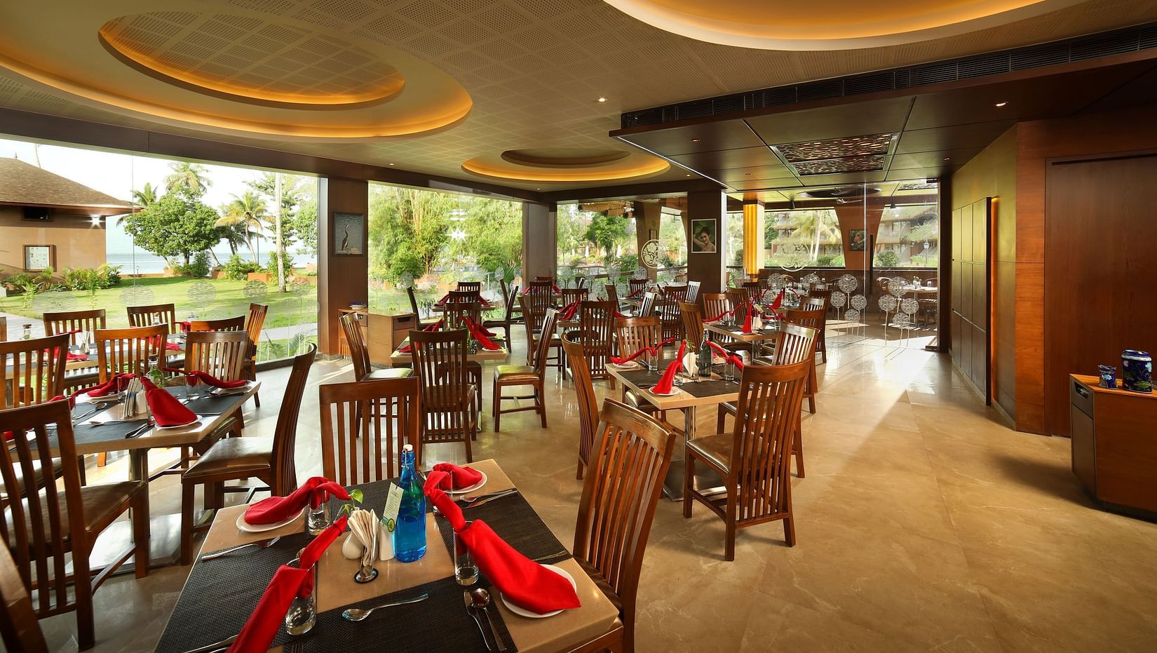 Aambal Restaurant at Uday Backwater Resort featuring tables arranged with outside views