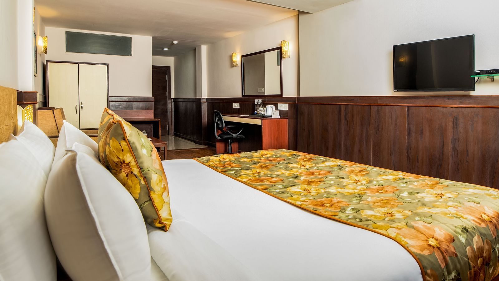 A side view of a bed in a room that has a TV on the wall | Summit Oakden Resort & Spa, Mall Road
