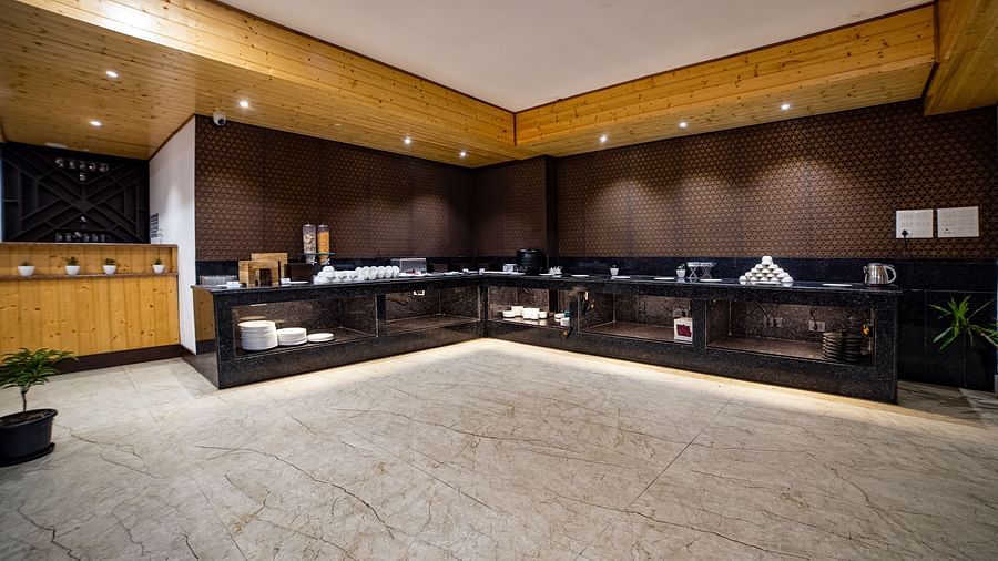 A service area  in Sumitel Hotel with dark cabinets, clean counters, and plates on the top